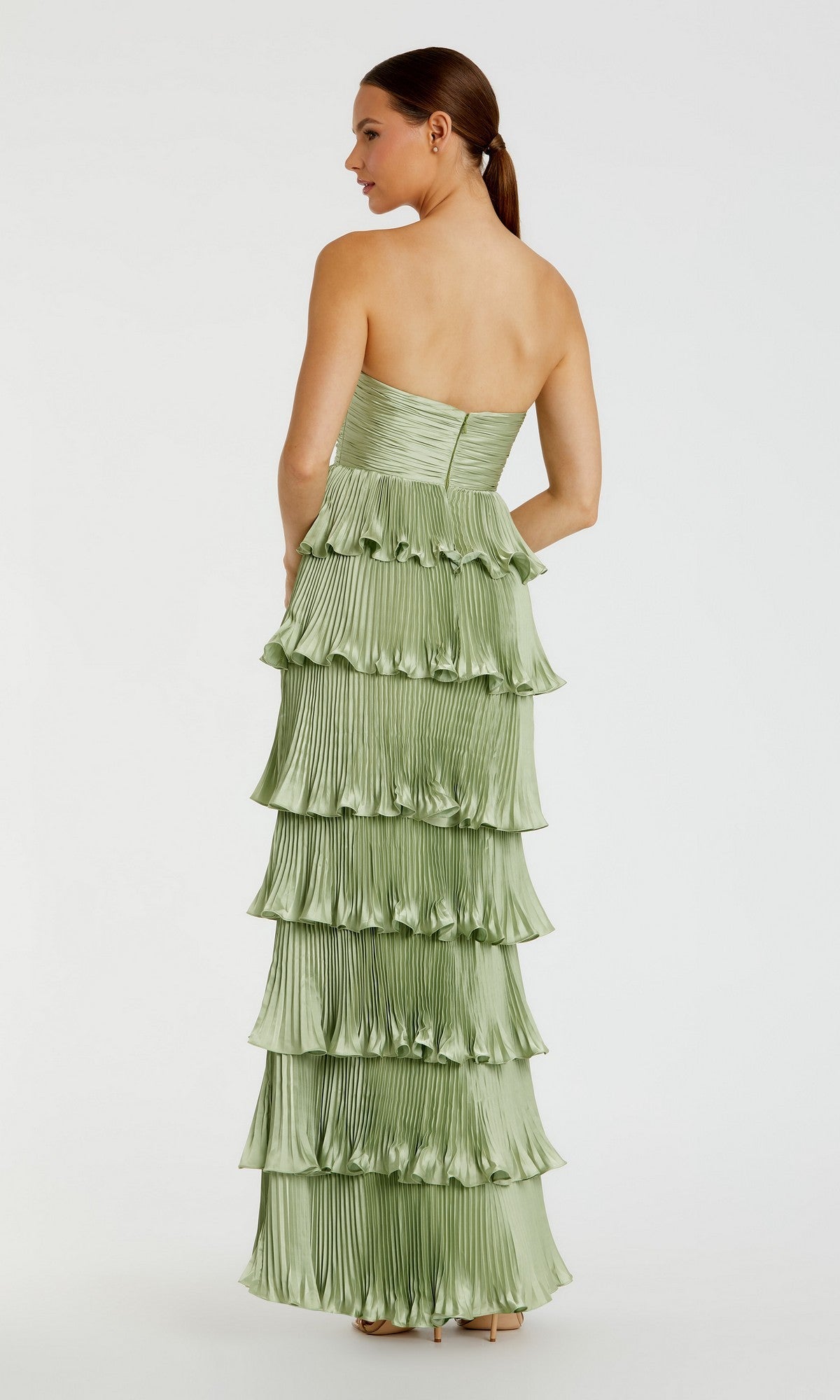 Woman in Mac Duggal 49981 Long Formal Dress—a floor-length, strapless light green gown with layered pleated ruffles—standing and facing away.